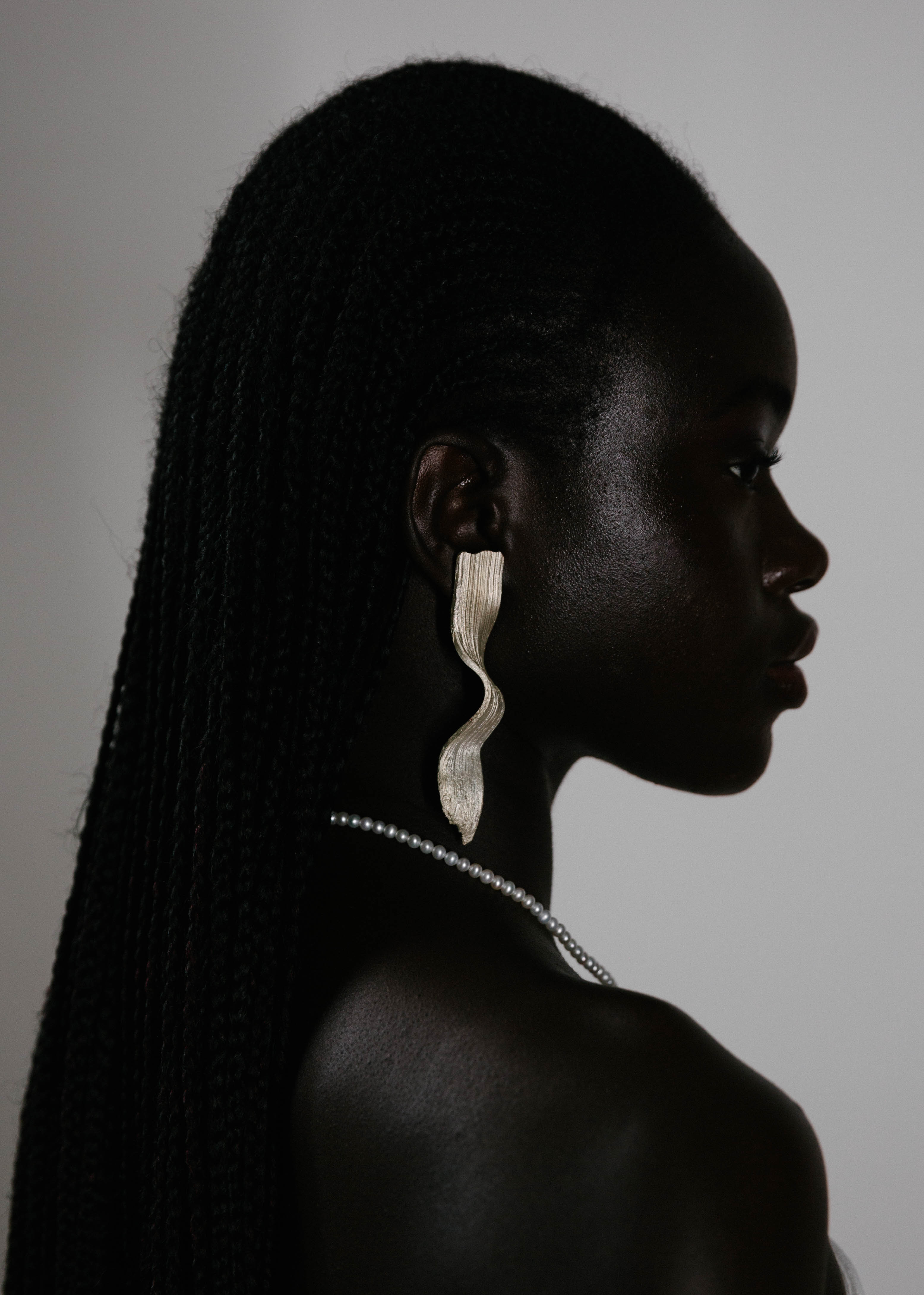 Handcrafted silver earring worn by model with white background