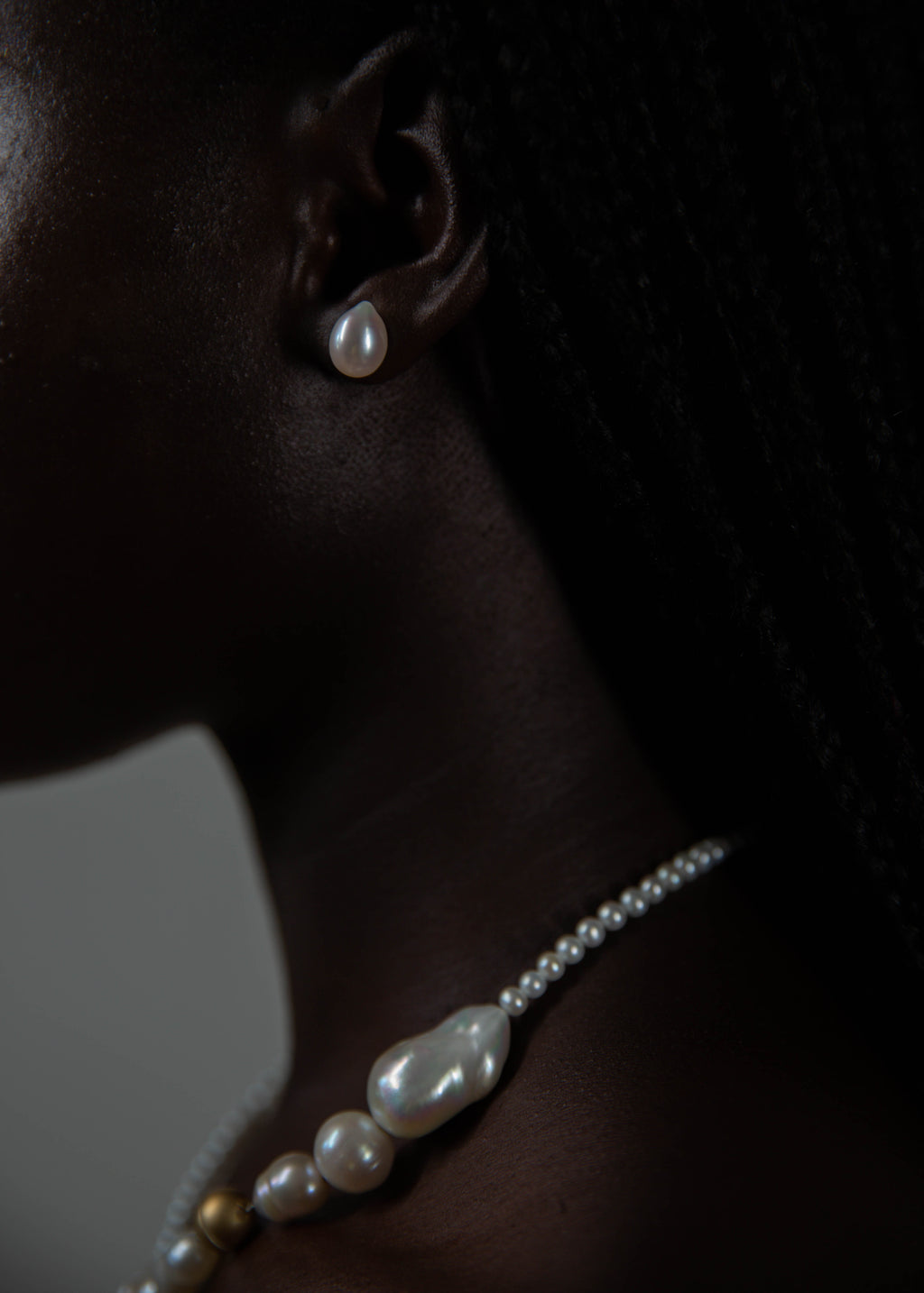 Model wearing handcrafted pearl necklace and earring from the side