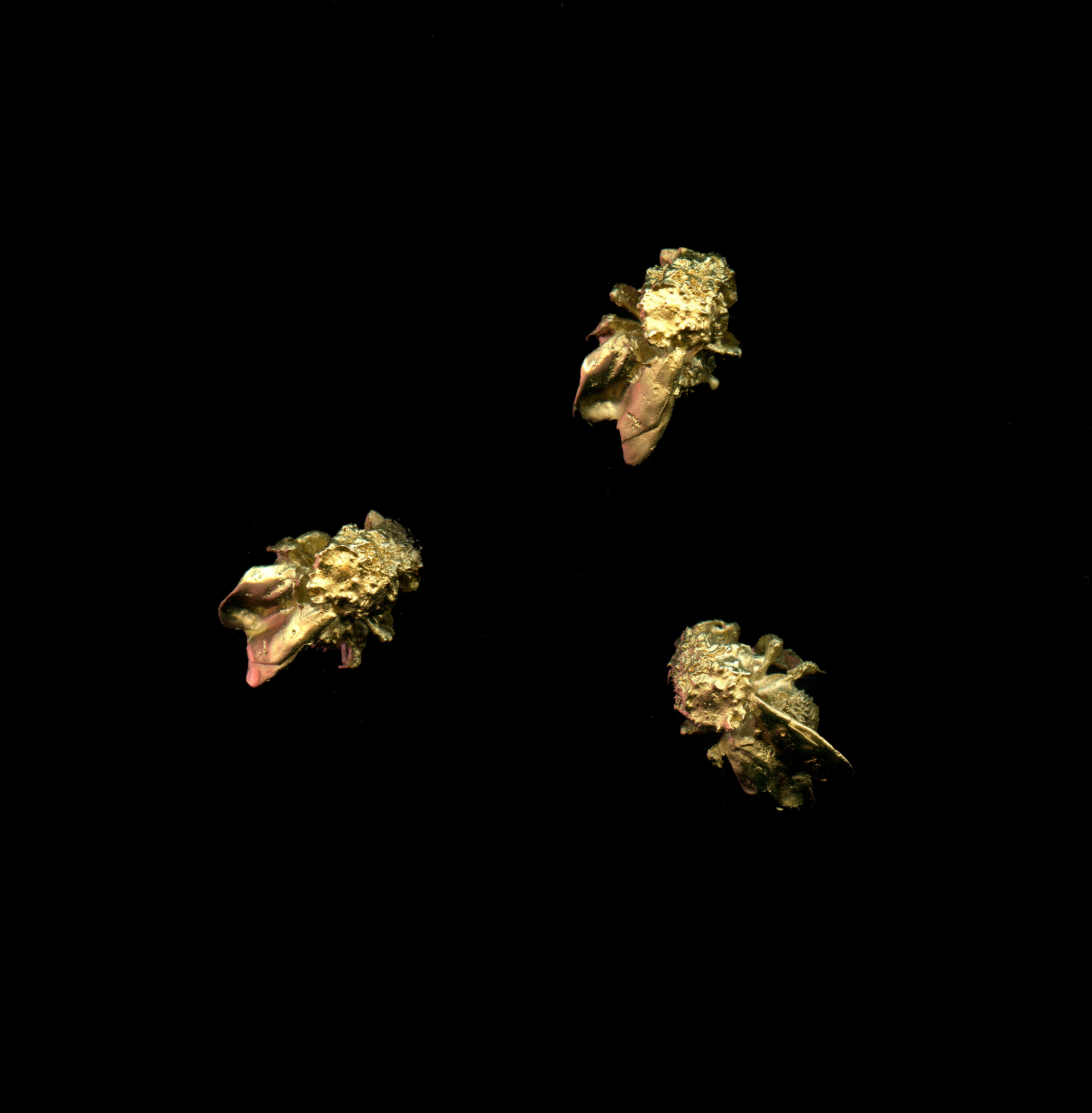 Three handcrafted gold bumblebee-shaped earrings on a black background