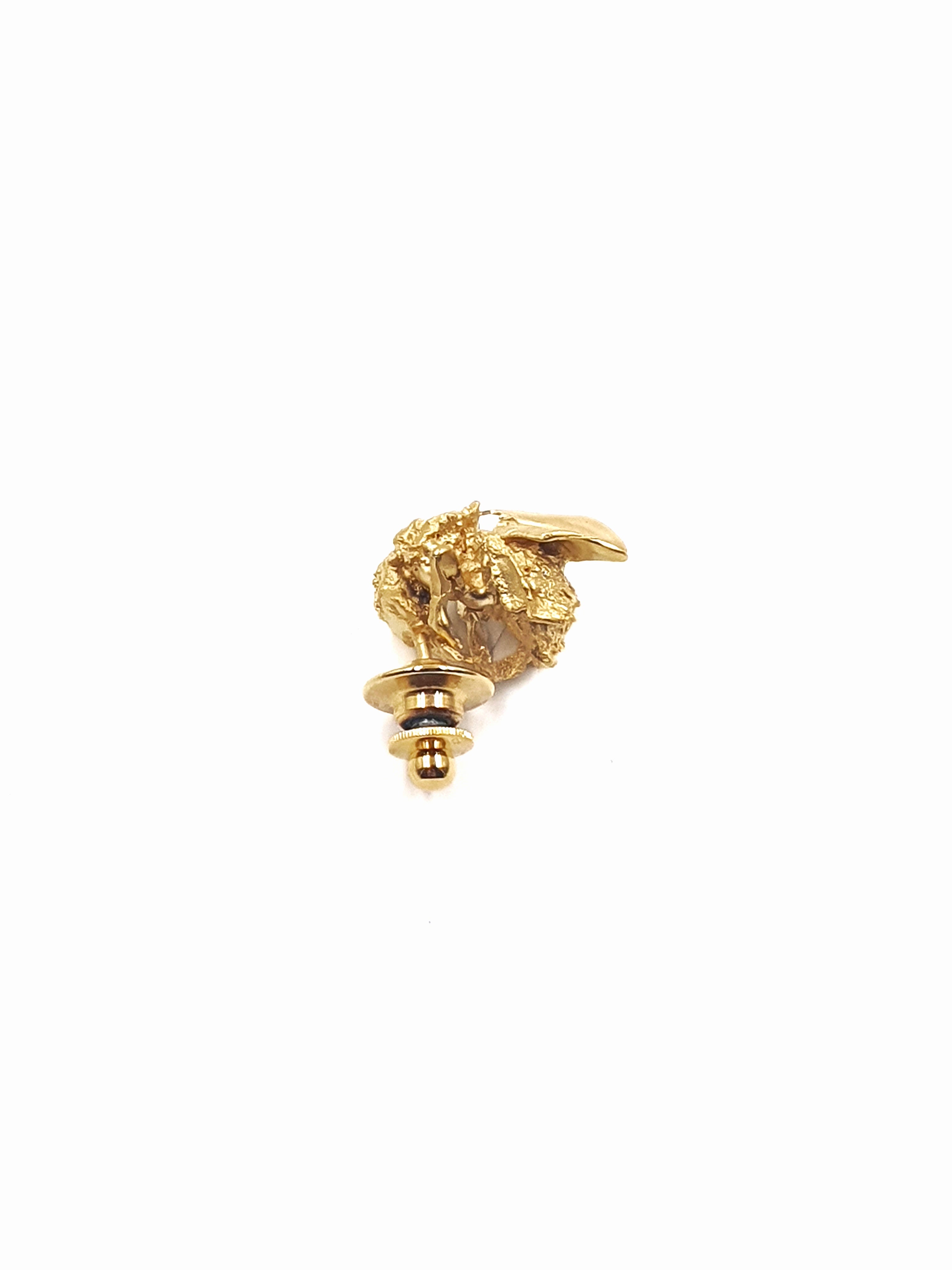 Gold handcrafted bumblebee brooch on a white background