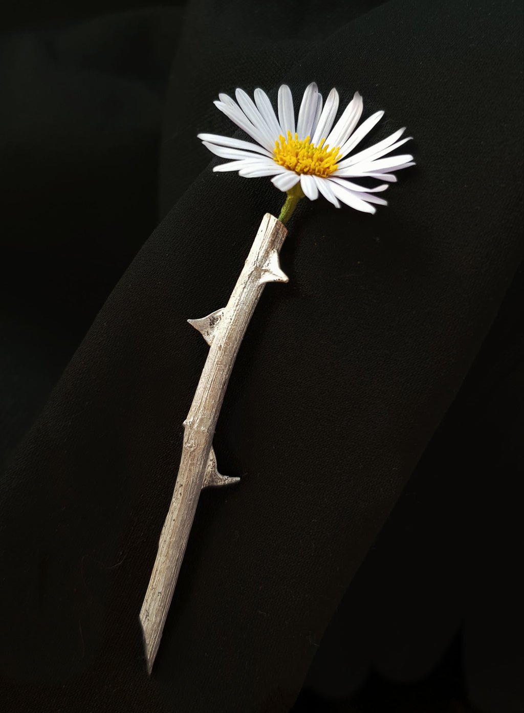 handcrafted Silver thron brooch on black background with flower inside