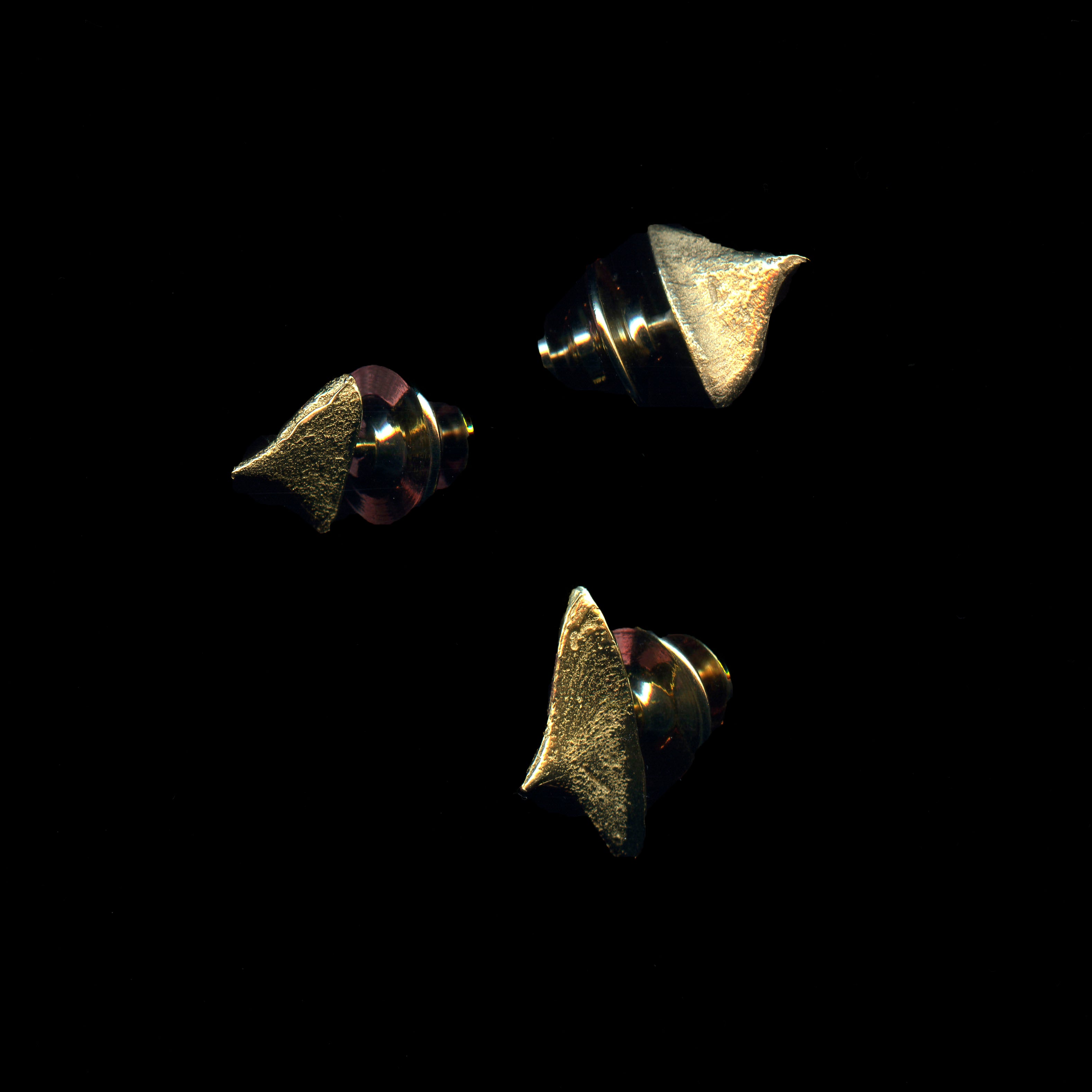Three handcrafted gold thorn brooches on black background