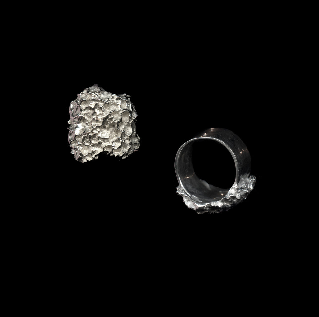 Two handcrafted silver rings on a black background
