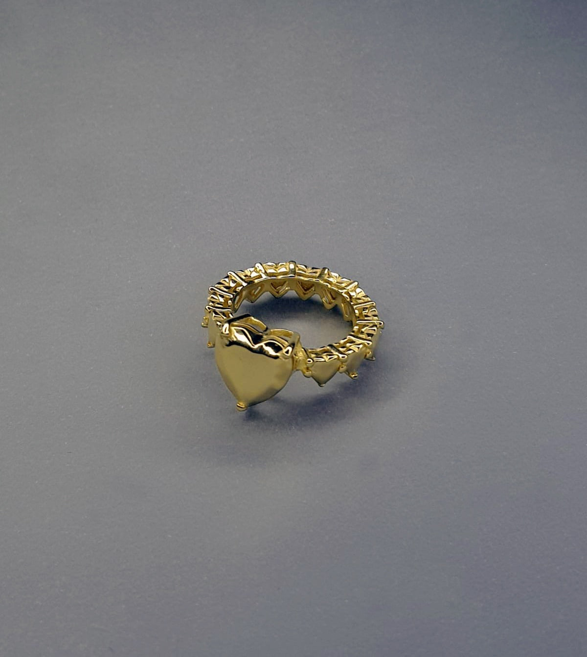 handcrafted gold ring on grey background
