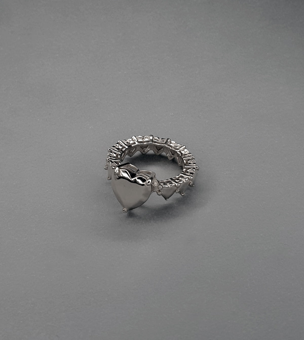 handcrafted Silver ring with heart designs on a gray background