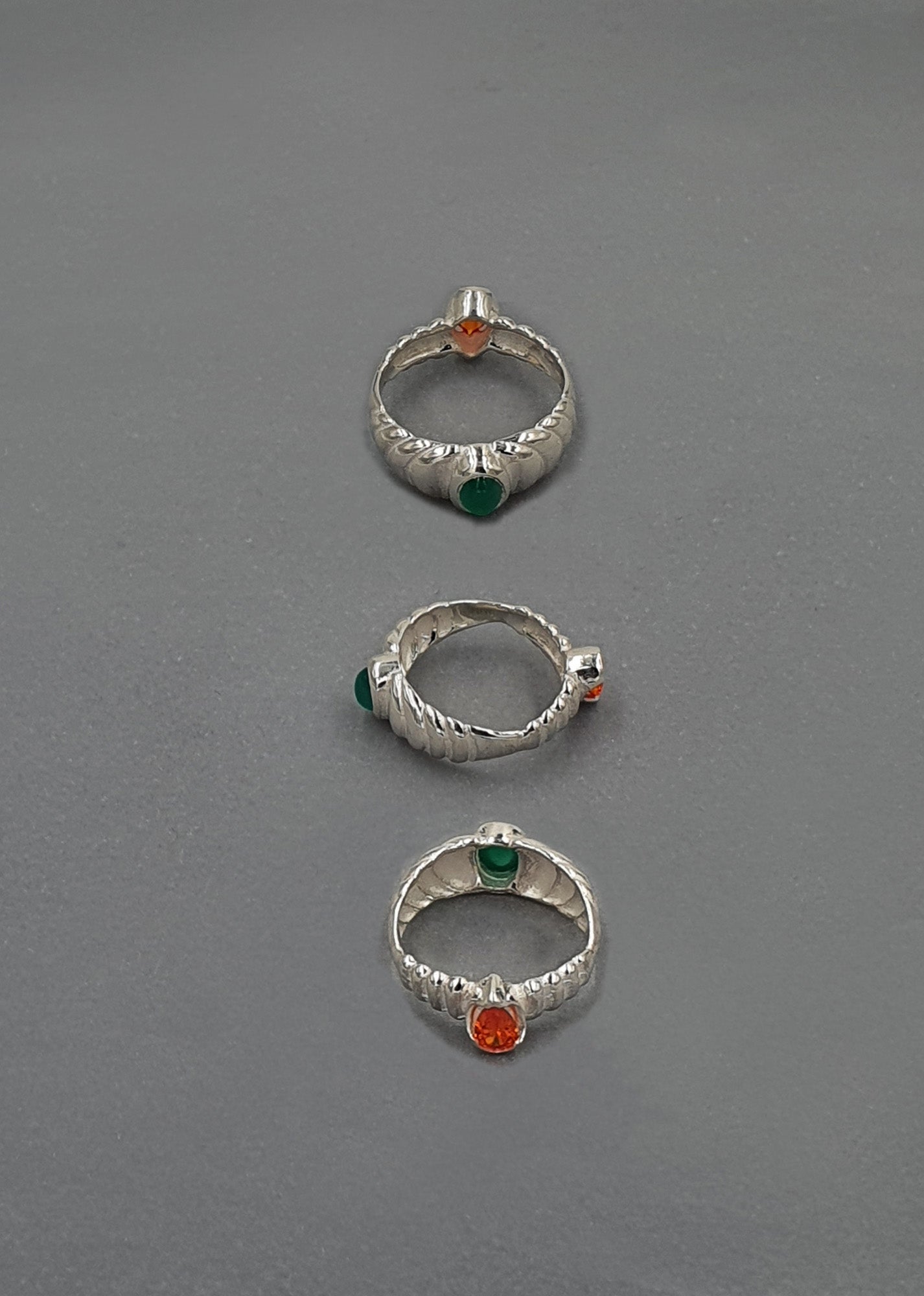 handcrafted silver rings on grey background