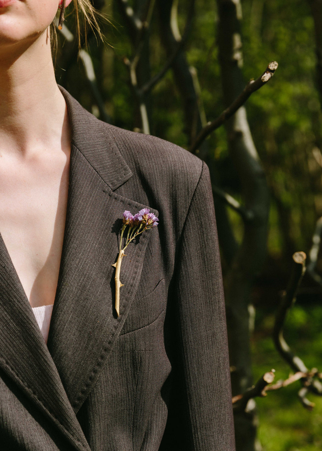 Handcrafted gold rosa brooch with flower inside with nature in background