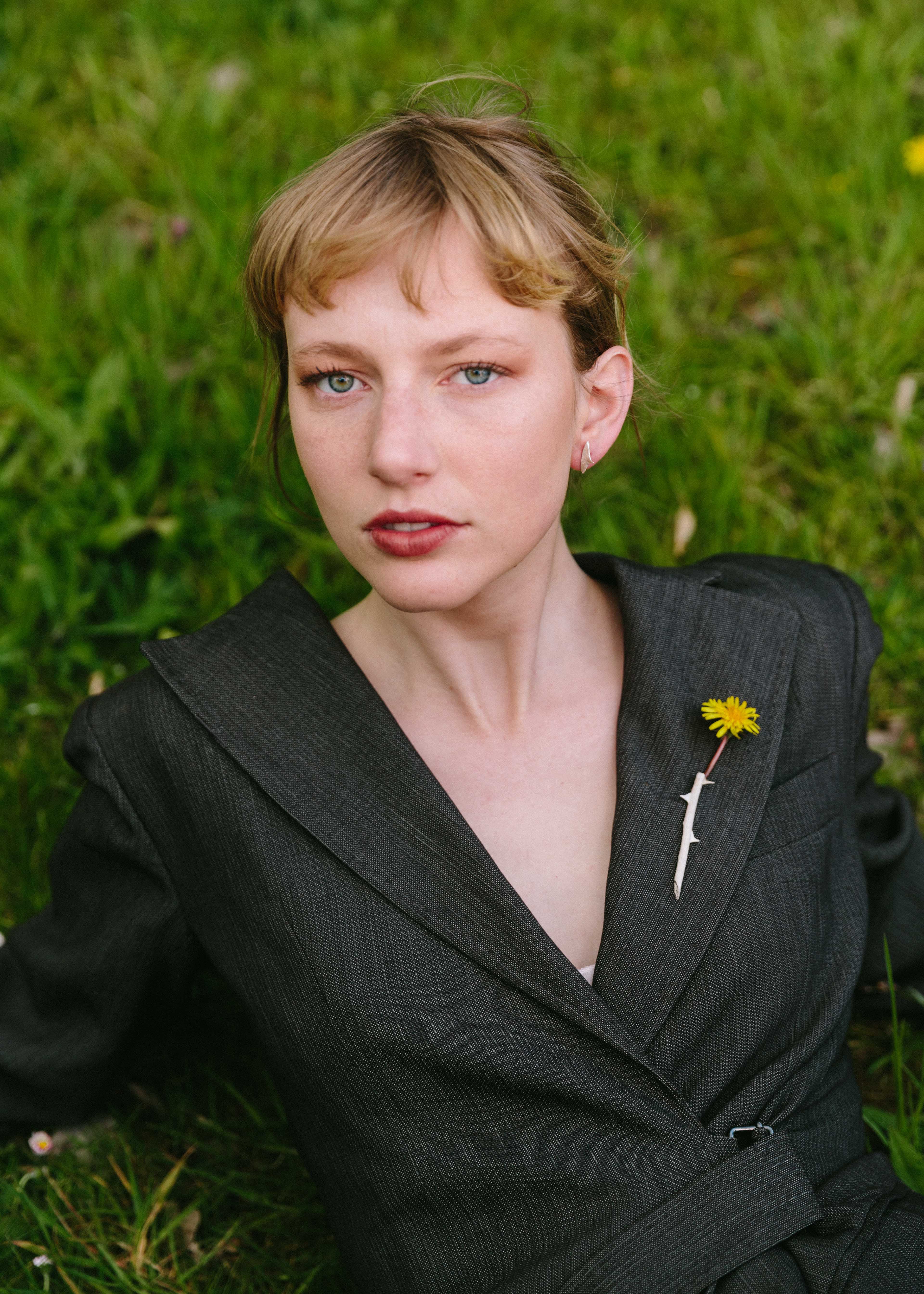 handcrafted Rosa brooch worn on jacket with yellow flower inside
