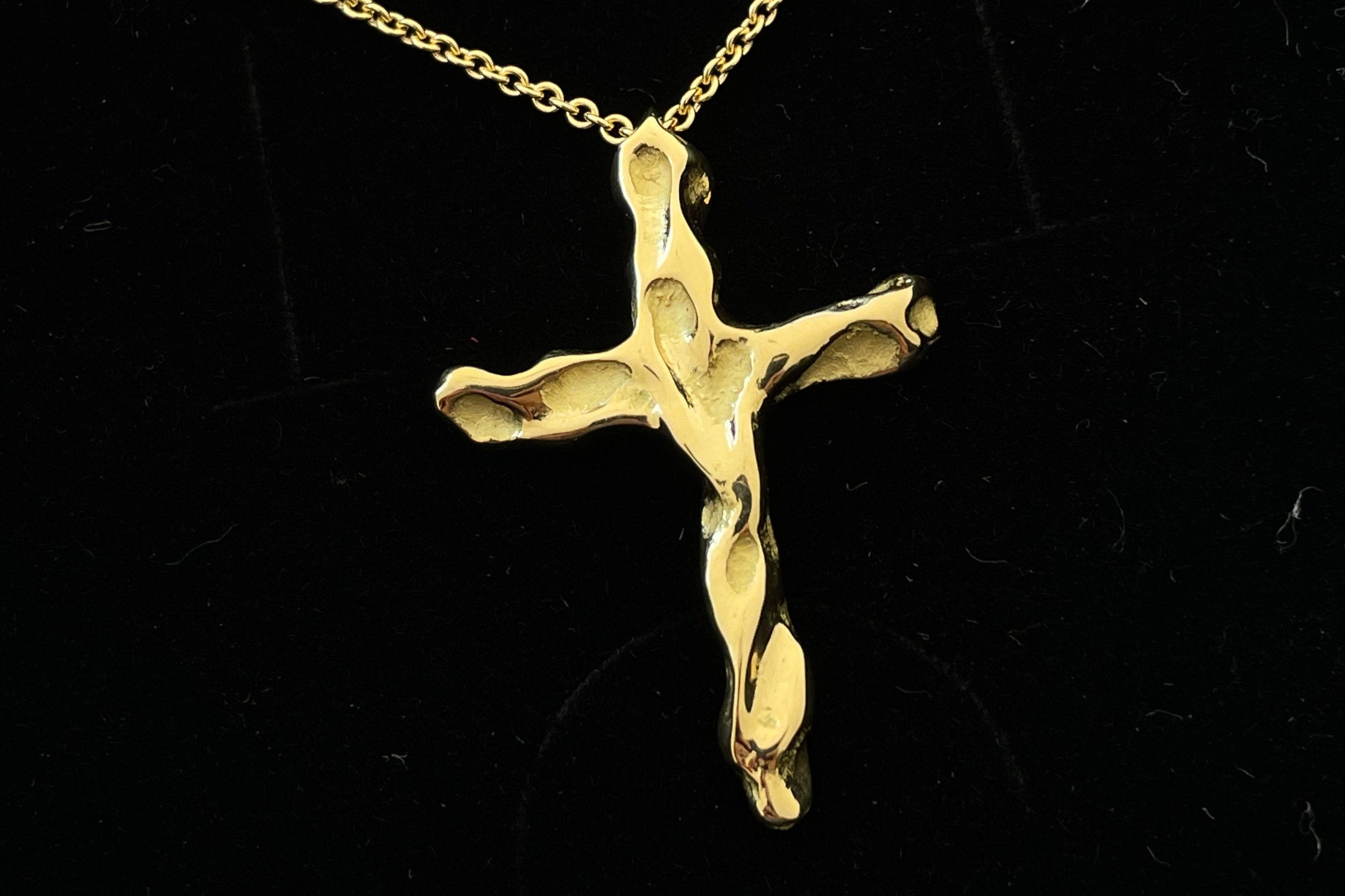 handcrafted Gold cross pendant on a black background